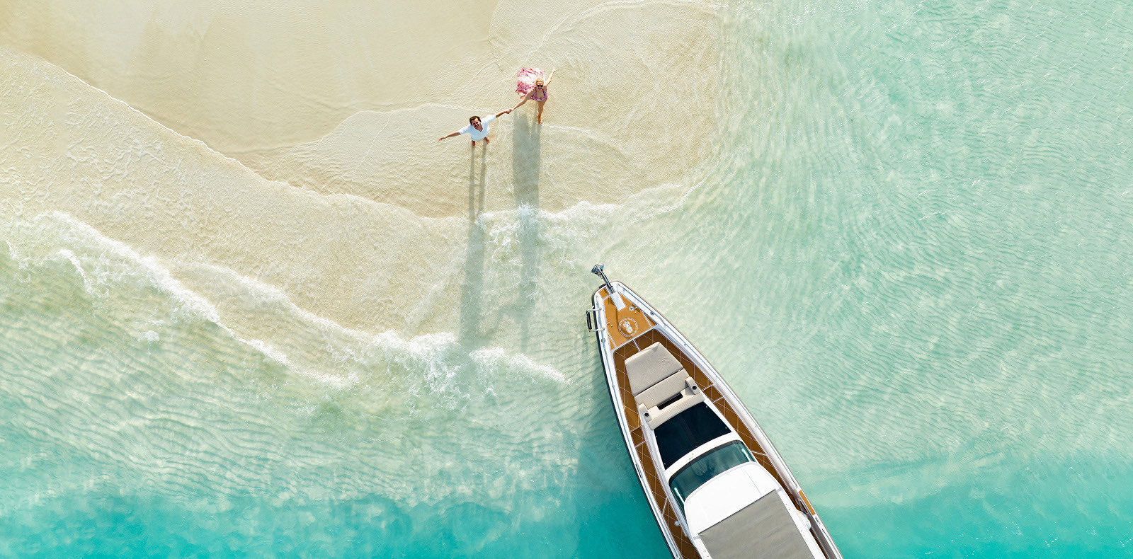 Aerial view of a couple beside a boat on a Turks & Caicos sandbar