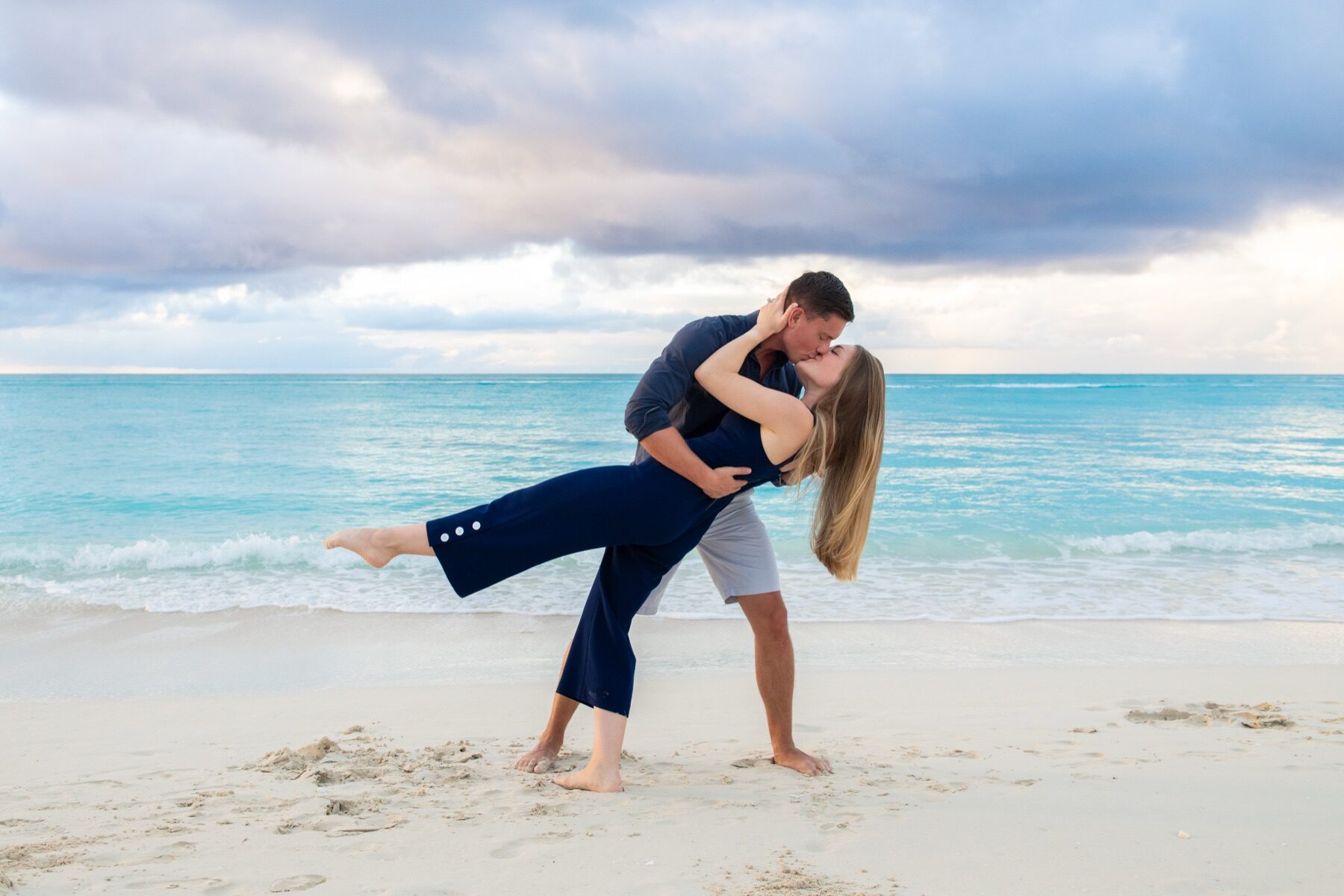 Man dipping his partner low for a kiss on a Turks and Caicos beach