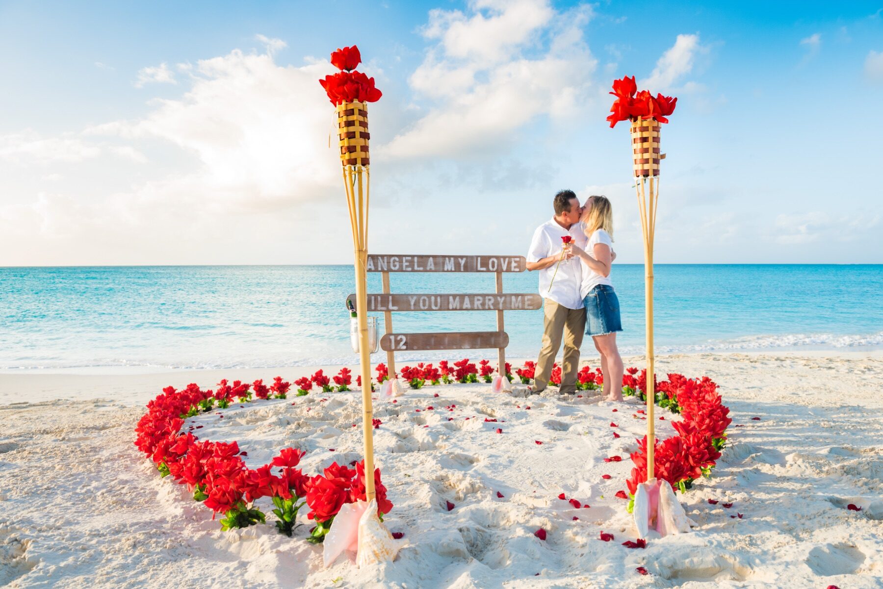 Couple kissing inside a heart of roses lit by torches, Turks and Caicos