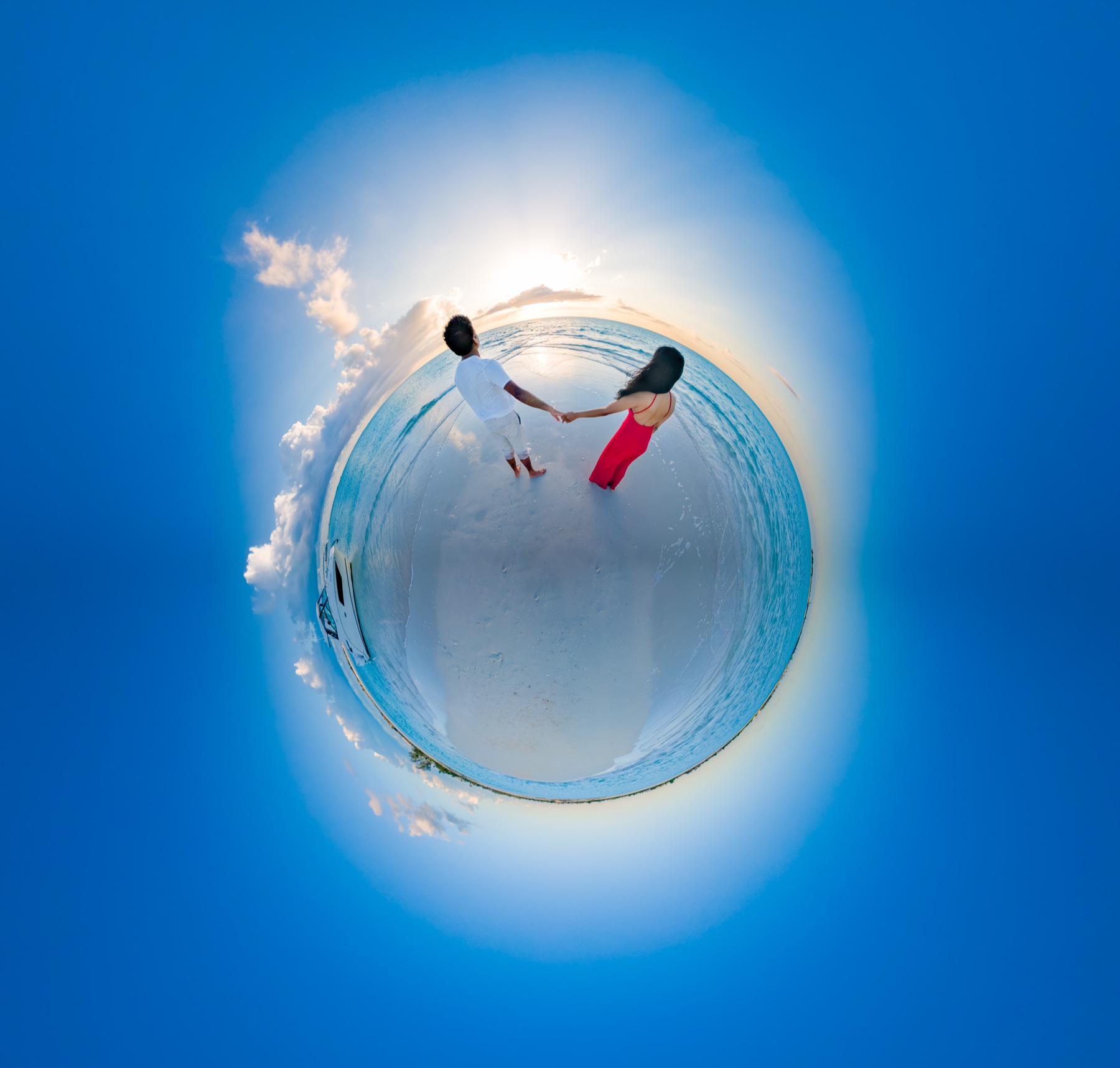 Little planet panorama of a couple holding hands on a sunlit beach