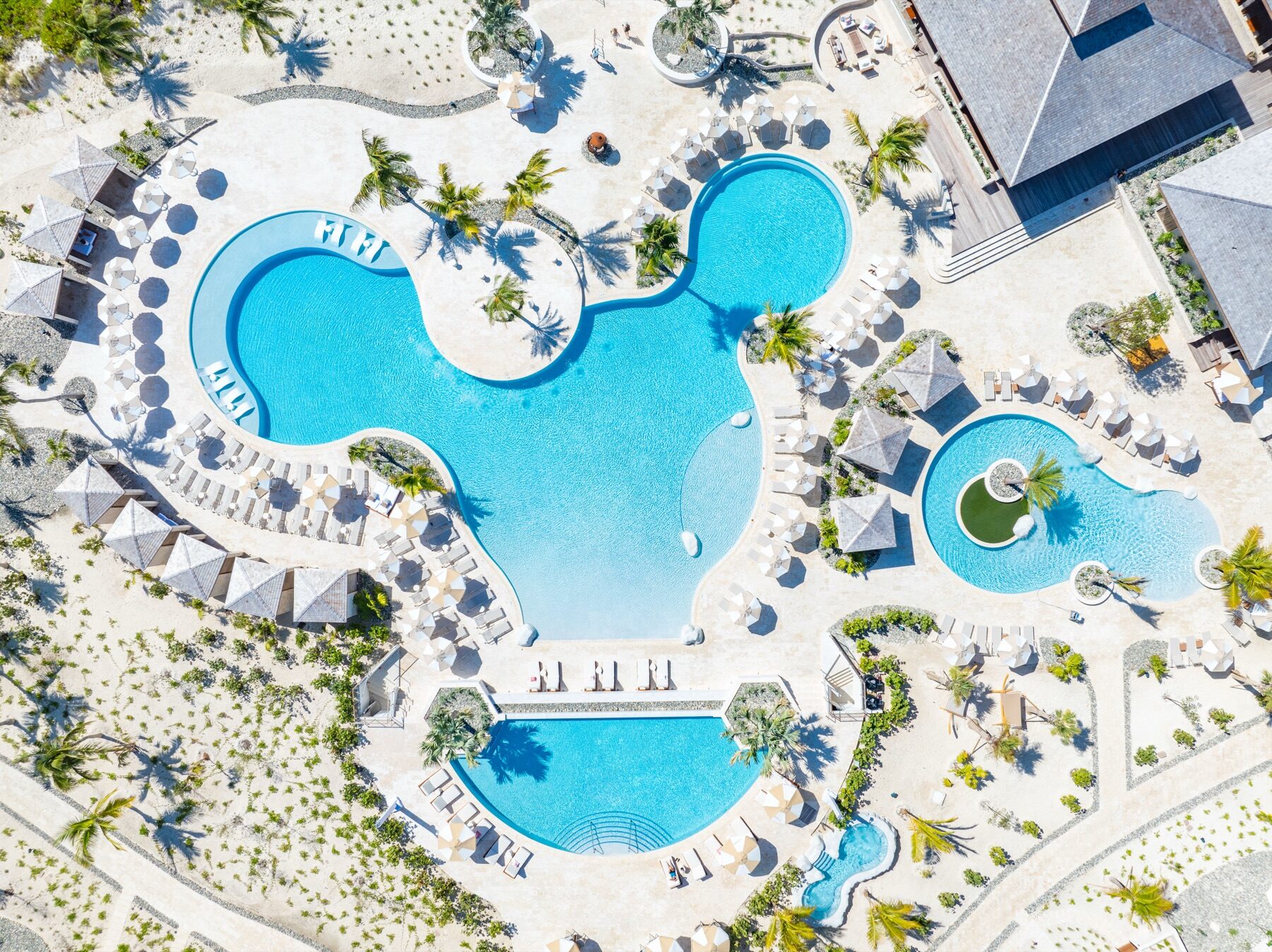 Aerial view of a resort pool complex shaped with curving lobes and islands