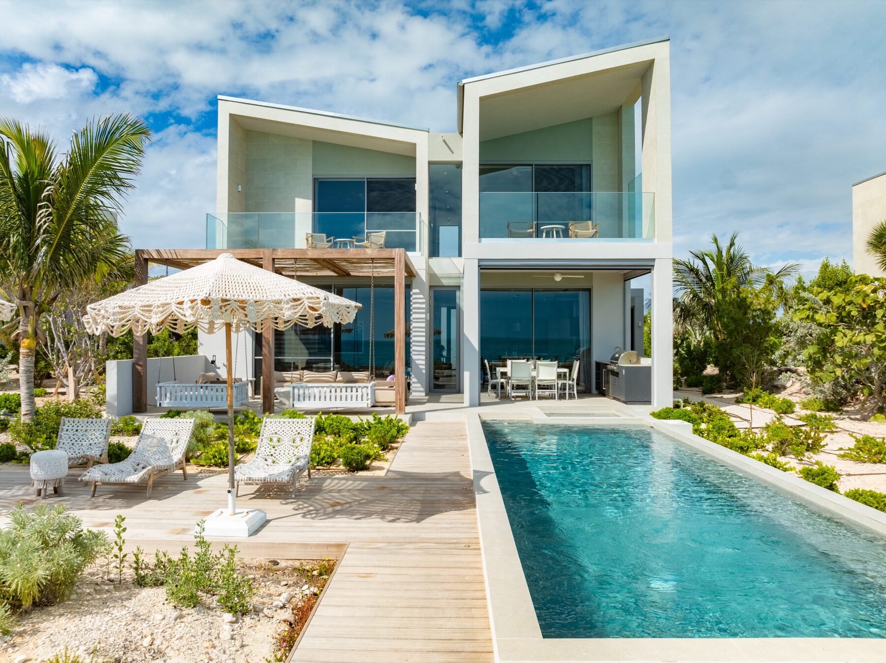 Modern beachfront villa with an angular roofline beside a lap pool