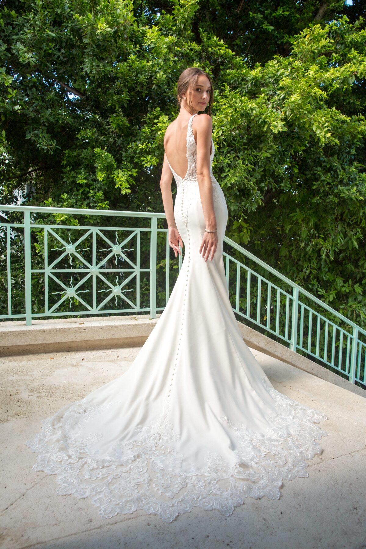 Bride in fitted gown looking back over her shoulder on a Turks and Caicos terrace