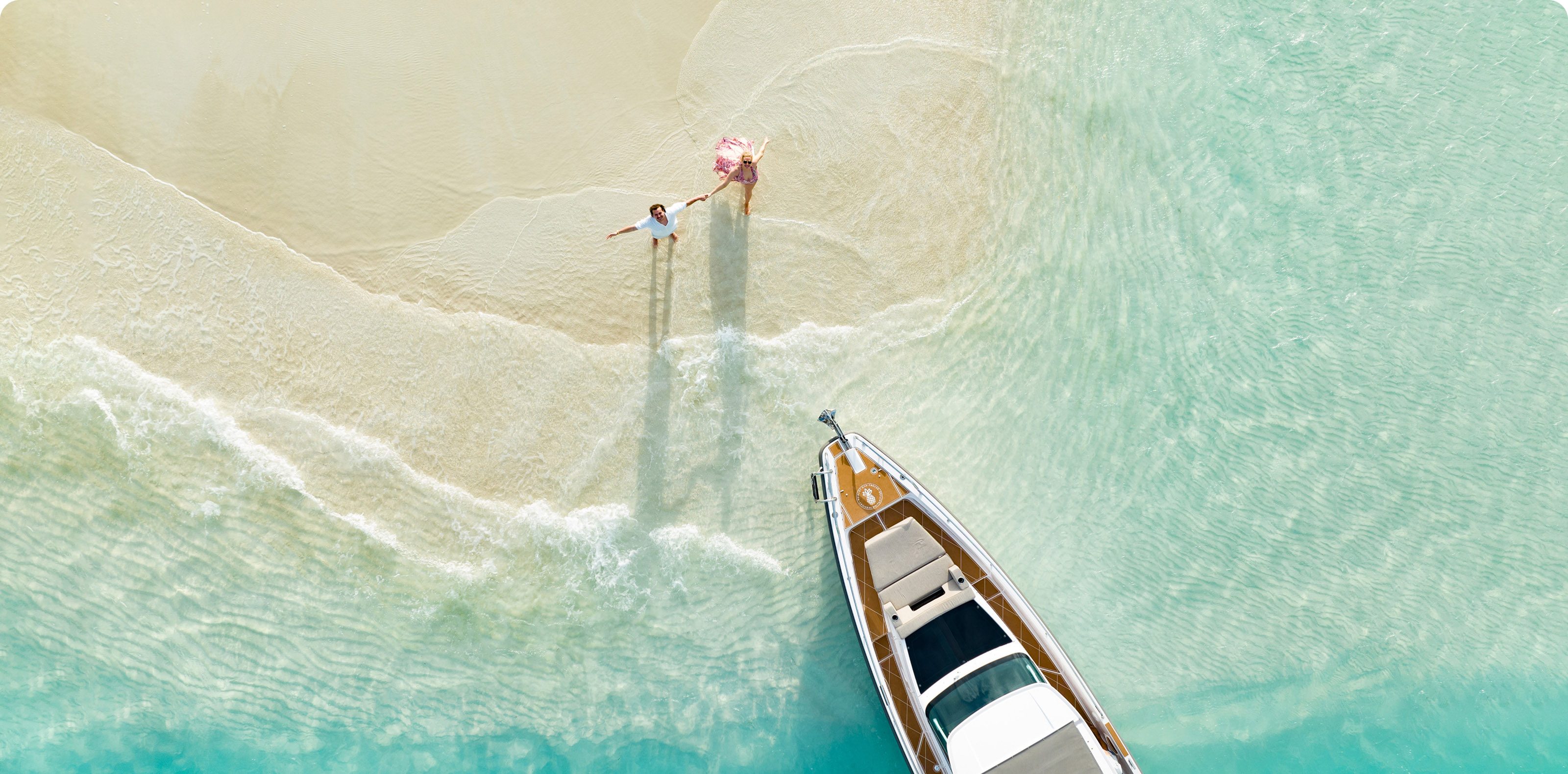 Aerial view of a couple beside a boat on a Turks & Caicos sandbar