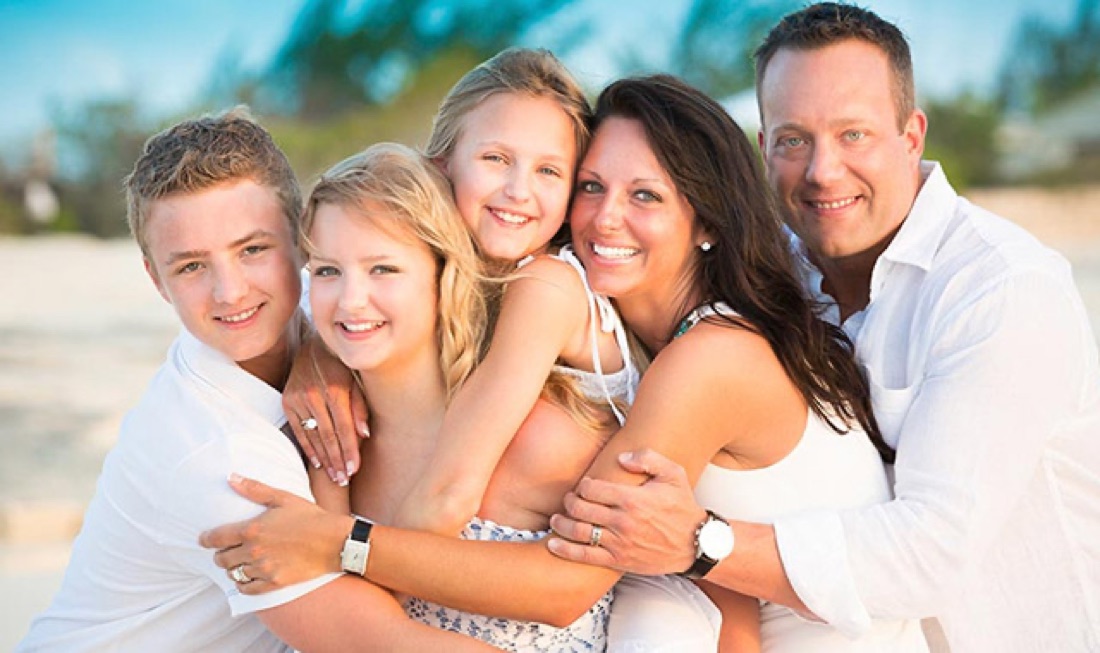 Family of five hugging on a Turks and Caicos beach