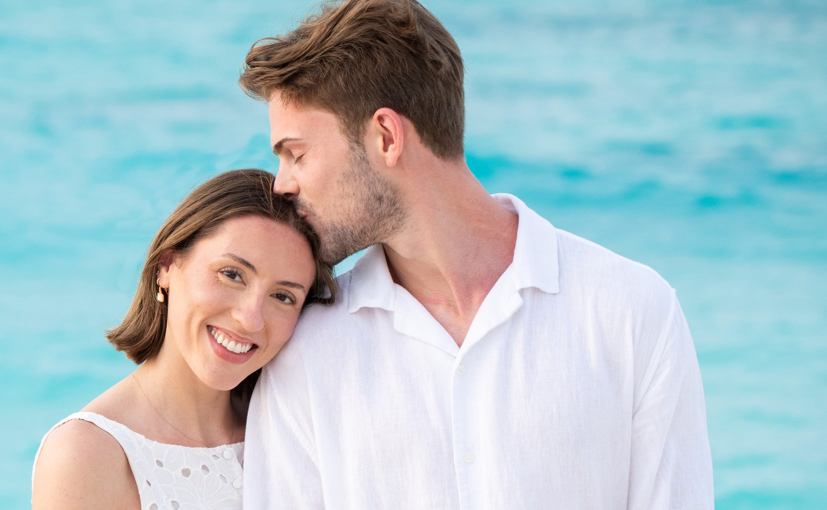 Man kissing his partner on the forehead during a portrait session