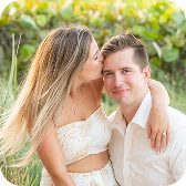 Couple sharing a kiss among coastal grasses